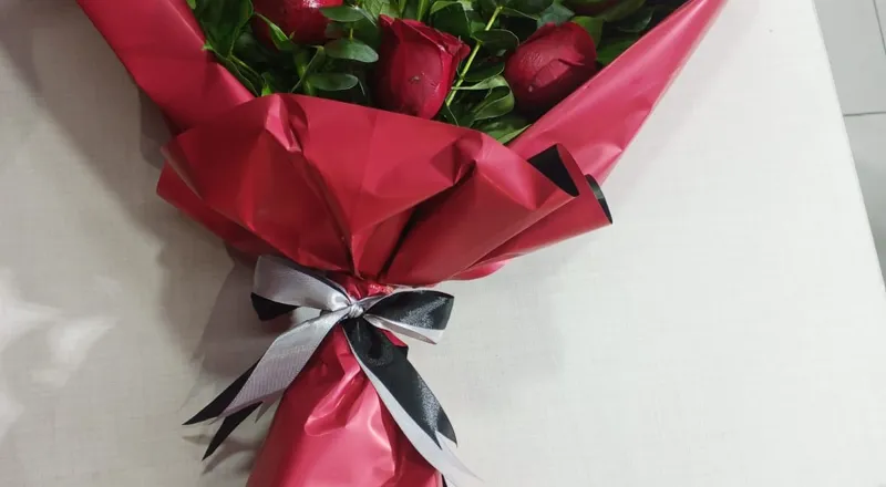 Six red roses with eucalyptus in red and black wrapper with silver bow